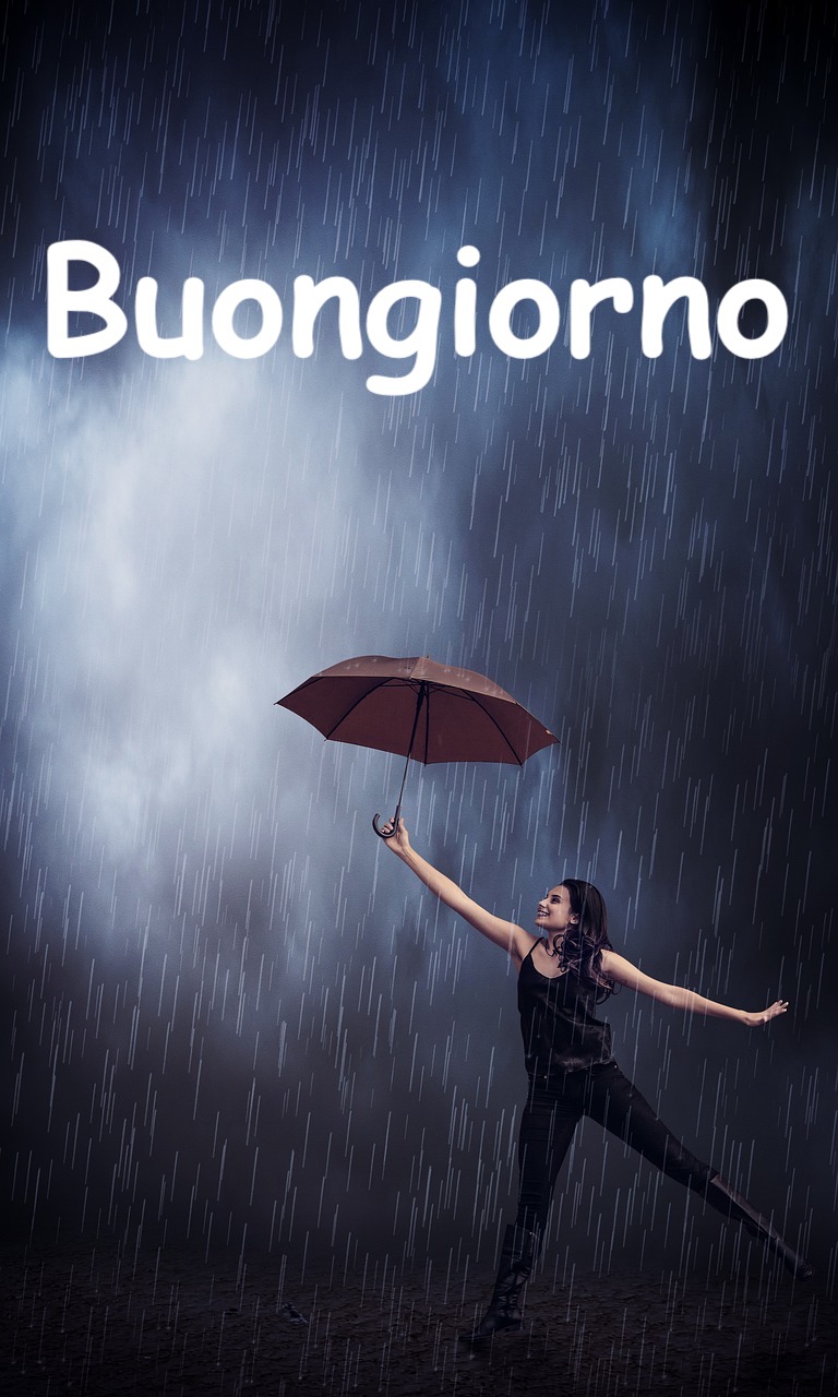 una bella ragazza balla felice con l'ombrello sotto la pioggia 